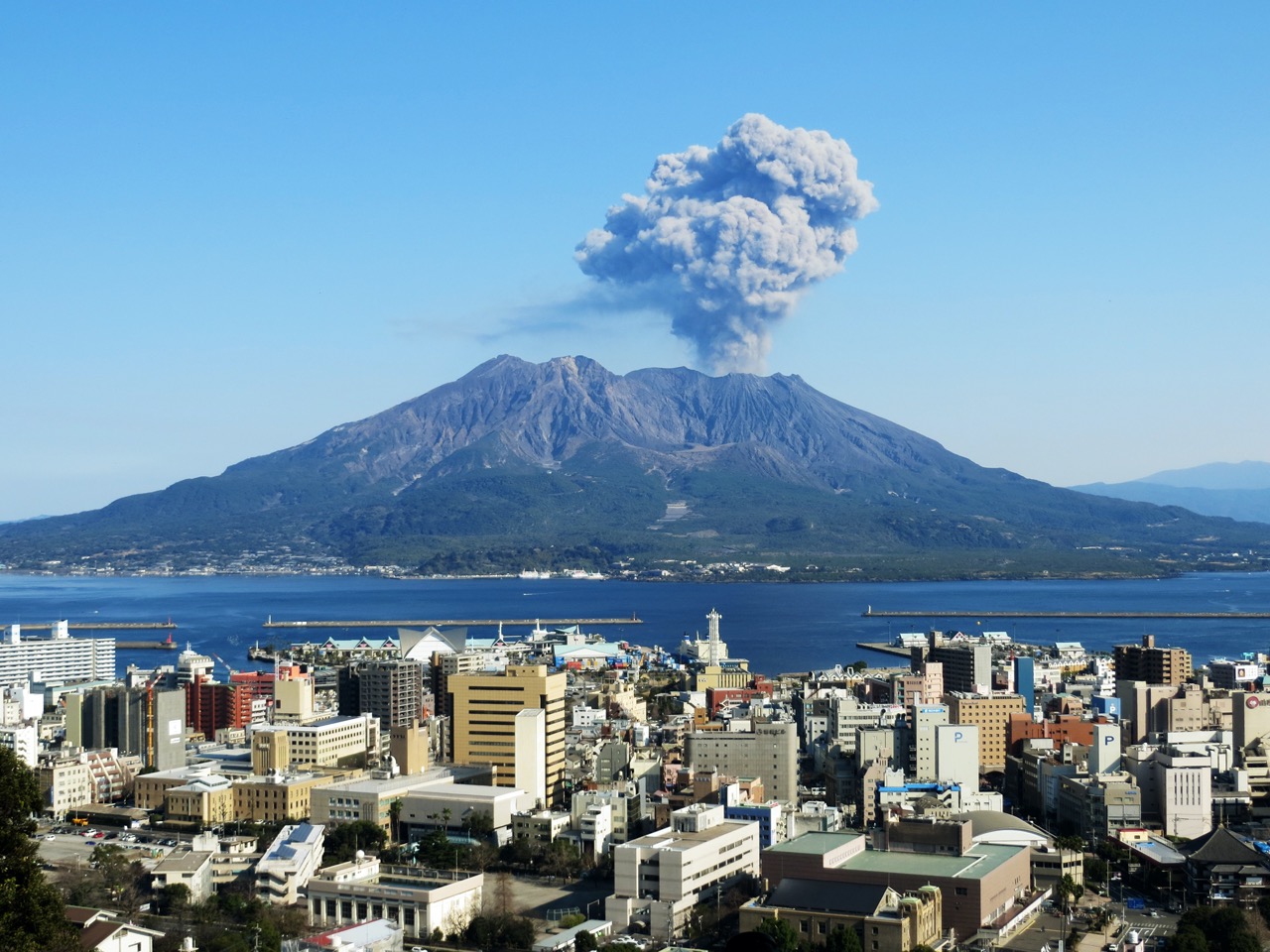 鹿児島湾と桜島、噴煙を上げる活火山と鹿児島市街の風景